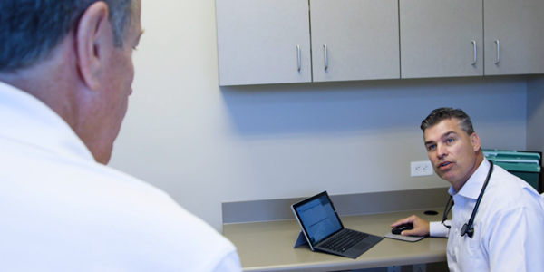 Dr. Spencer examines a patient while Holon identifies care gaps