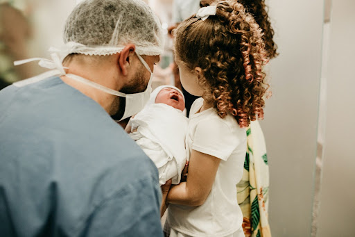 Doctor with newborn and child