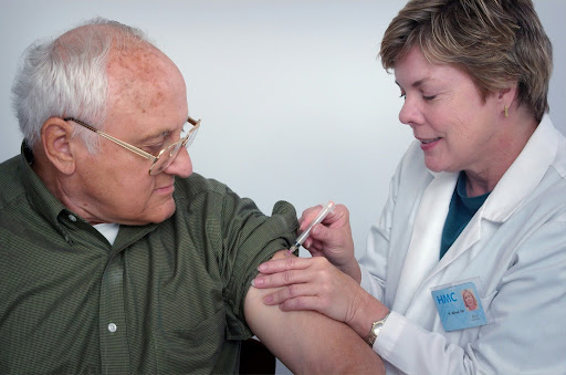 Doctor injecting an elderly