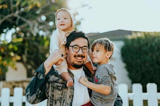 man carrying two kids